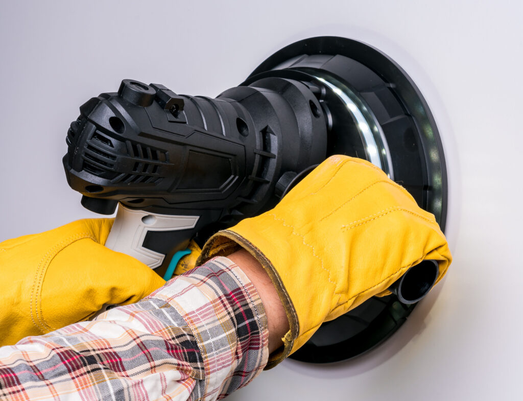 Electric putty grinder in the hands of a worker